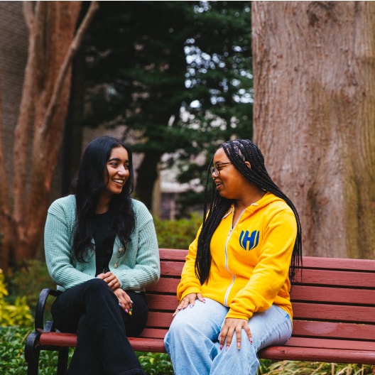Screens screenshot of two women sitting on a bench.