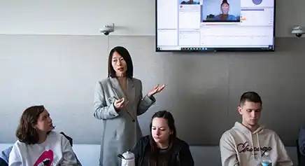 Professor teaching a class in front of a smart board