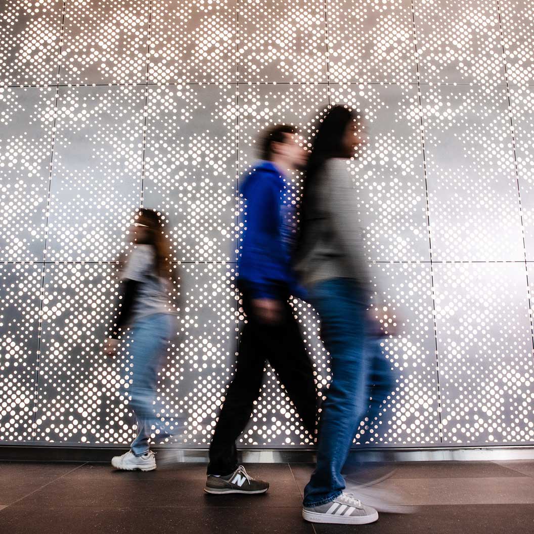 Students walking in front of pattern