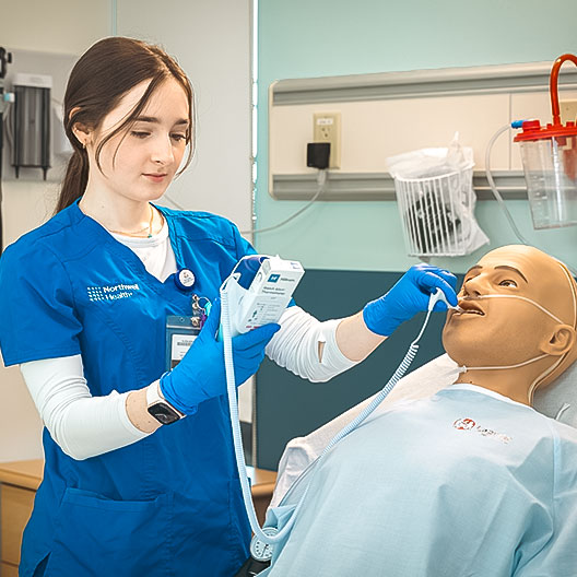 Student using medical device on training dummy
